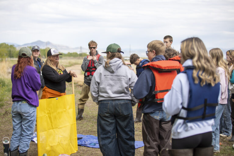 high school students gather around a teacher at The Grove in East Helena