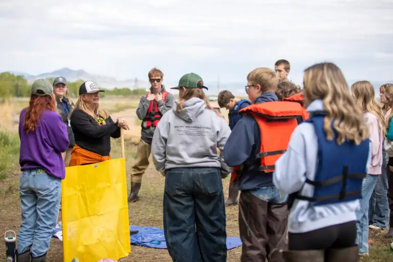 high school students gather around a teacher at The Grove in East Helena